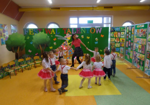 Dzieci tańczą w kole wiązanym z panią.
